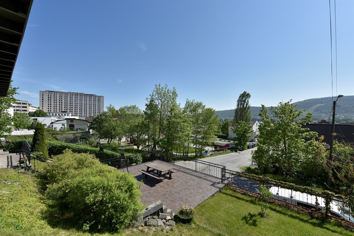 Tomten er velstelt og vakkert opparbeidet med åpent plenareal, trapper, pyntelige forstøtningsmurer, gjerder og stilig smijernsrekkverk. Galleribilde