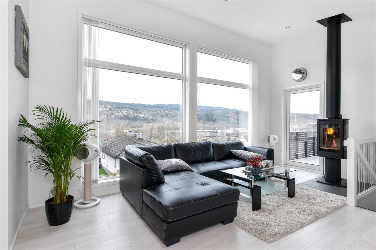 De store vinduene har lamellgardiner og det er monter en moderne peisovn med stålpipe, noe som gir mulighet for å nyte knitrende flammer fra sofakroken. Galleribilde