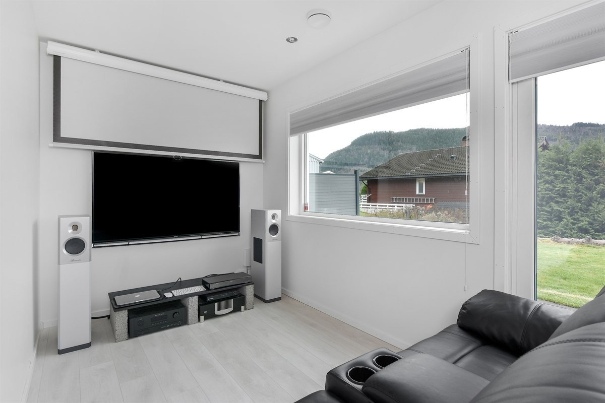 Boligen innehar i tillegg en flott separat tv-stue i første etasje med laminat på gulv, hvite vegger og god plass for møblement. Galleribilde