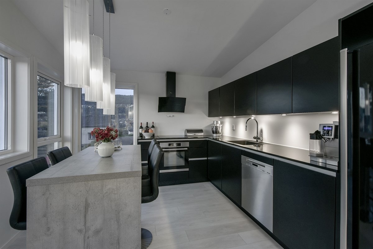 Kjøkkenet har benkebelysning og kompositt benkeplate med underlimt oppvaskkum. Galleribilde