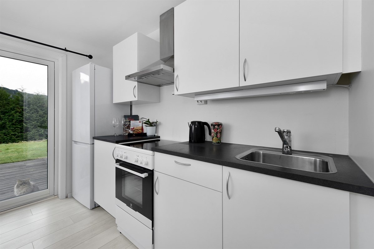 Endeveggen har gode vindusflater og det er utgang til en koselig, liten terrasseplatting med levegg mot hovedboligen. Galleribilde