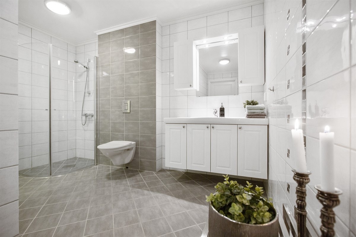 Stort bad med vegghengt wc og innredning i hvit profil Galleribilde