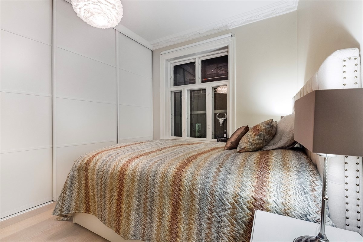 Romslig hovedsoverom med skyvedørsgarderobe Galleribilde