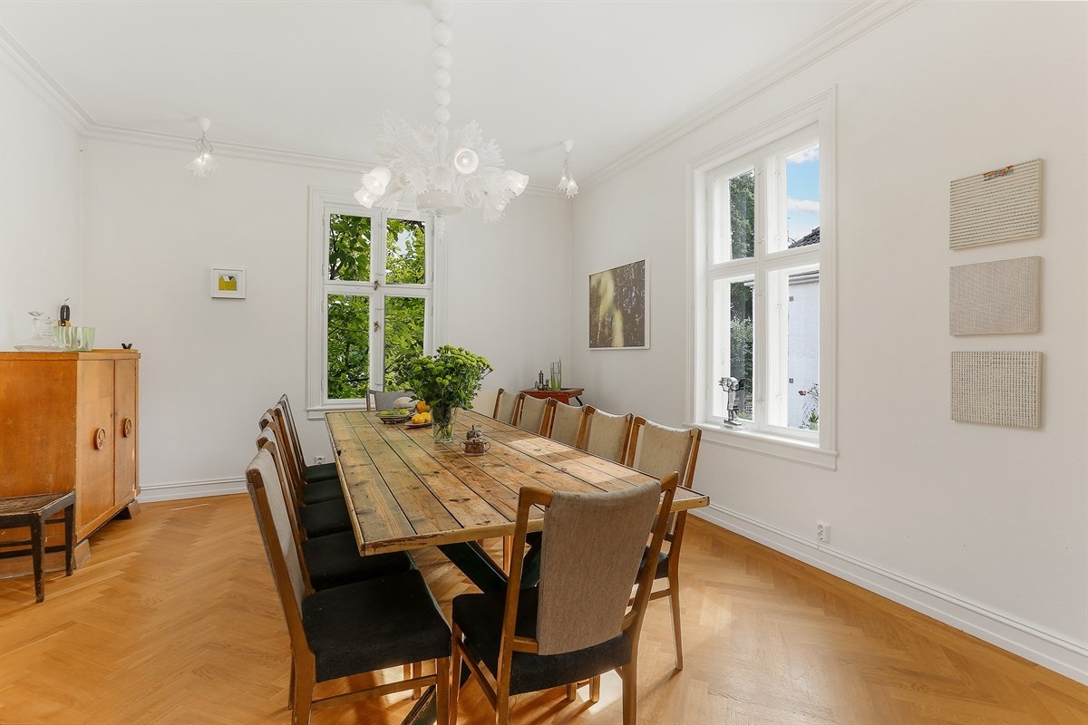 Spisestue med store vindusflater i tilknytning til kjøkken og videre ut til stue i 1. etasje Galleribilde