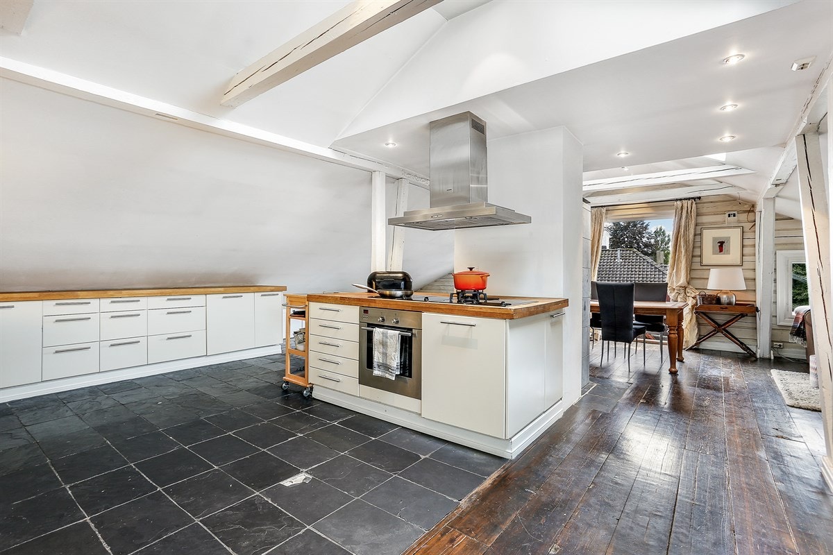 Romslig loftsetasje med stor kjøkkeninnredning med skap- og benkeplass Galleribilde