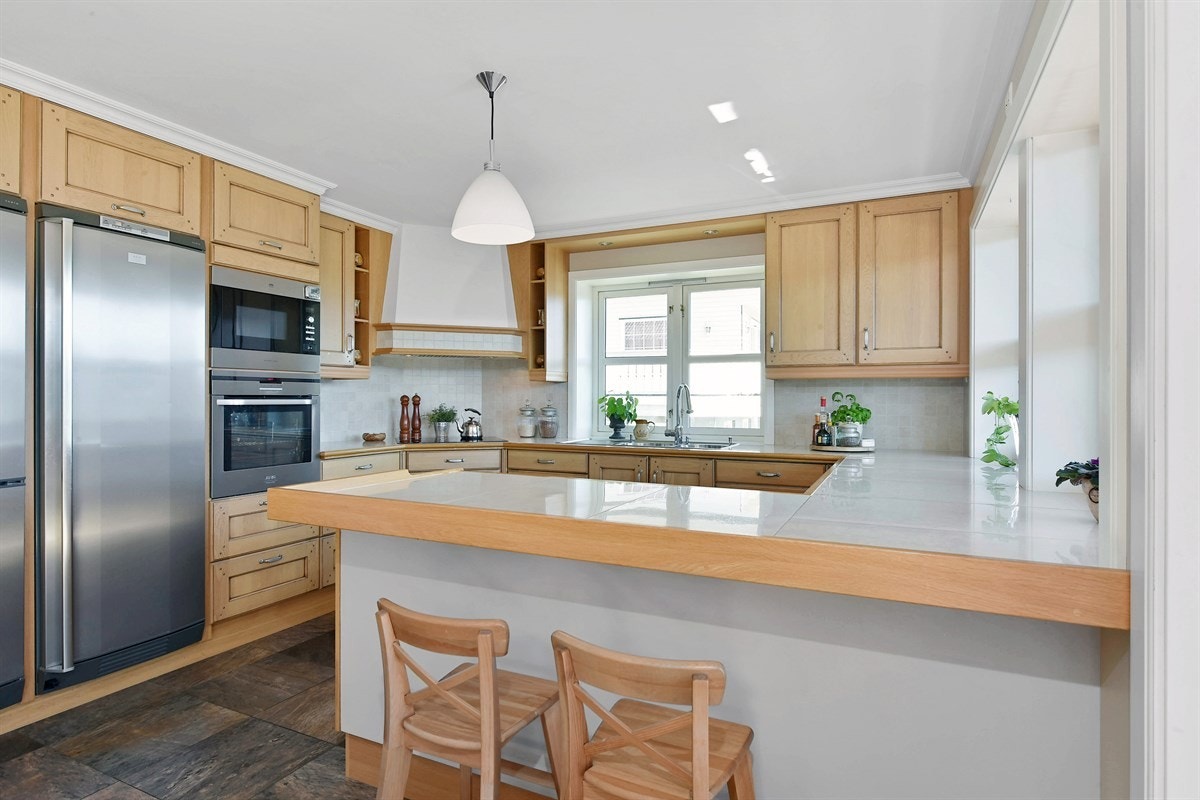 Kjøkkenet har en smart barløsning som gir både ekstra lagringsplass og et fint frokostområde. Galleribilde