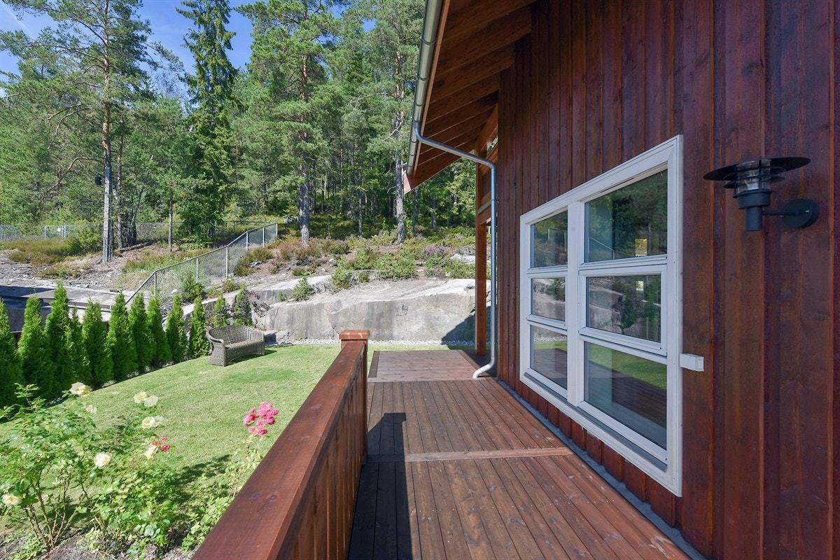 Eiendommen består av en pent opparbeidet, skrånende tomt med steinbelagt gårdsplass, gressplen, flott beplantning og noe naturtomt med fjell i dagen. Galleribilde