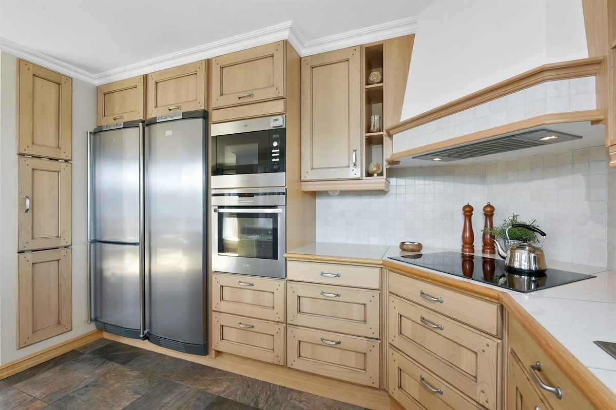 Den takhøye innredningen har profilerte eikefronter og fliser over benk. Galleribilde