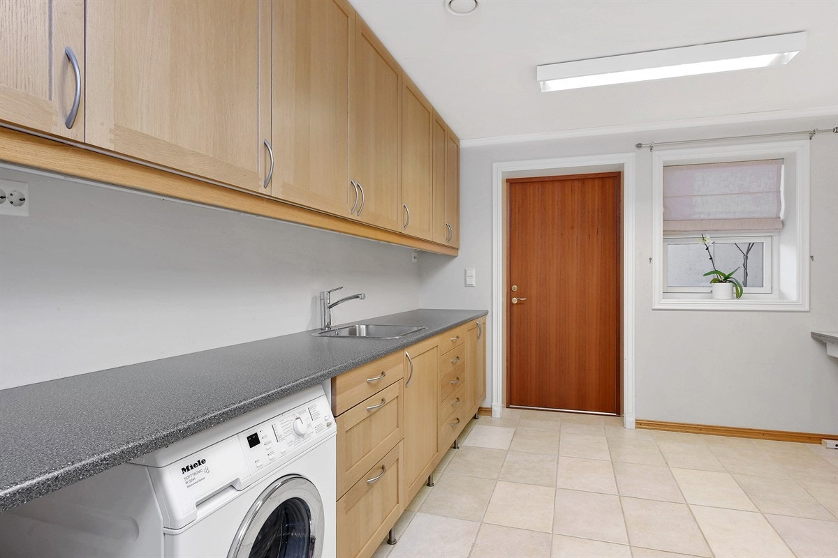 Vaskerommet har en romslig skapinnredning med over-og underskap samt en benkeplate med nedfelt vaskekum. Galleribilde