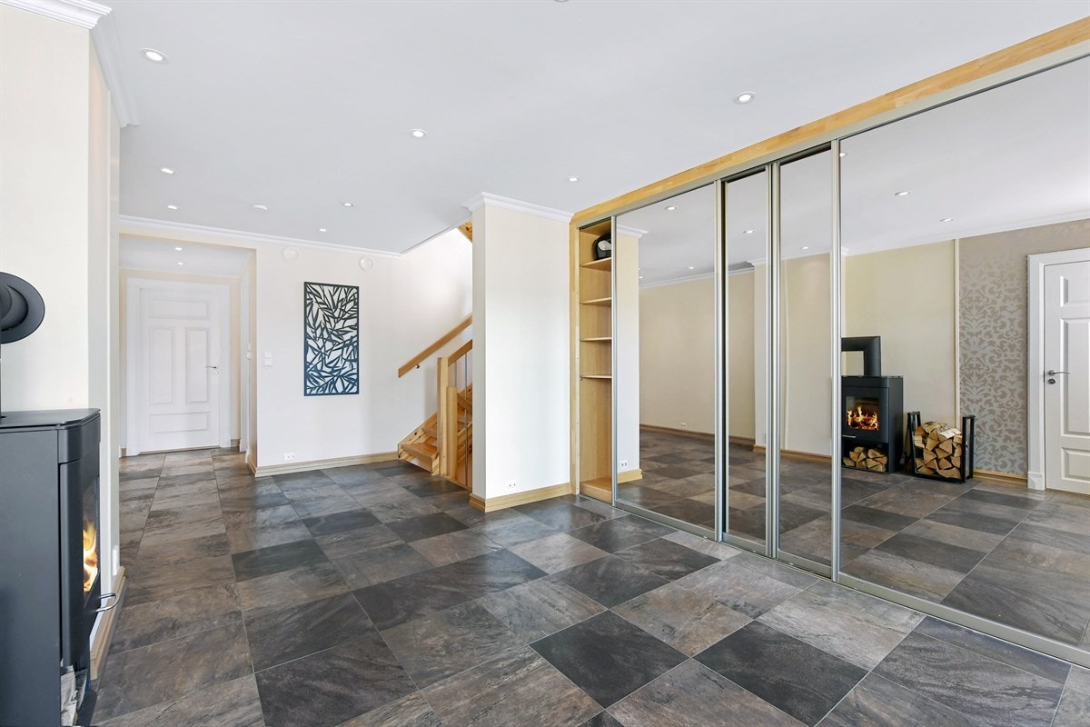 Entreen er svært romslig og er pent innredet med mørke gulvfliser, vegger i harmonisk fargetone, gulvvarme og downlights. Galleribilde