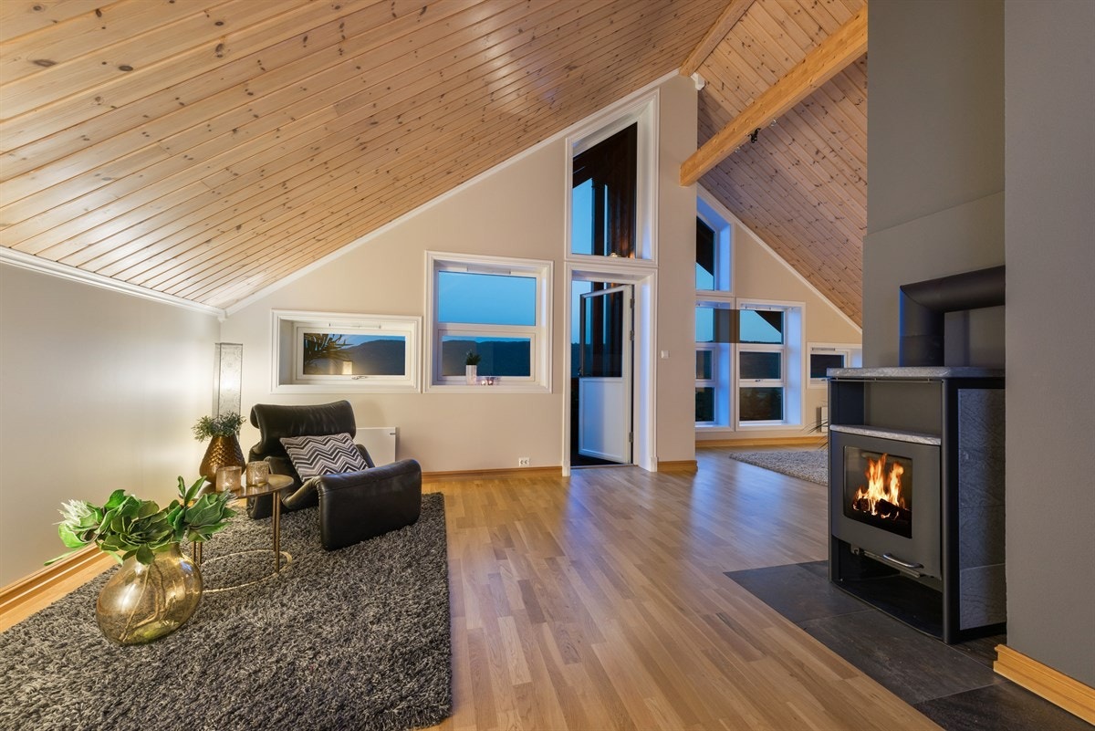 Rommet er utstyrt med vedovn med glassdør for ekstra varme og hygge, samt nisjer i veggen for oppbevaring av ved. Galleribilde