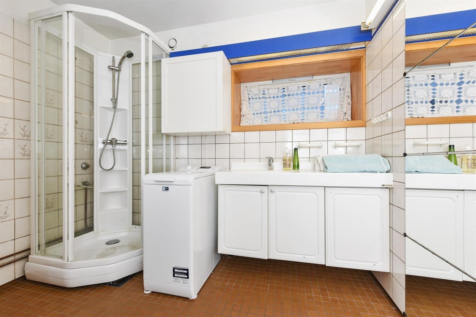 Stort og romslig flislagt bad med seperat toalett. Dusjkabinett, opplegg for vaskemaskin og servant med skap. Galleribilde