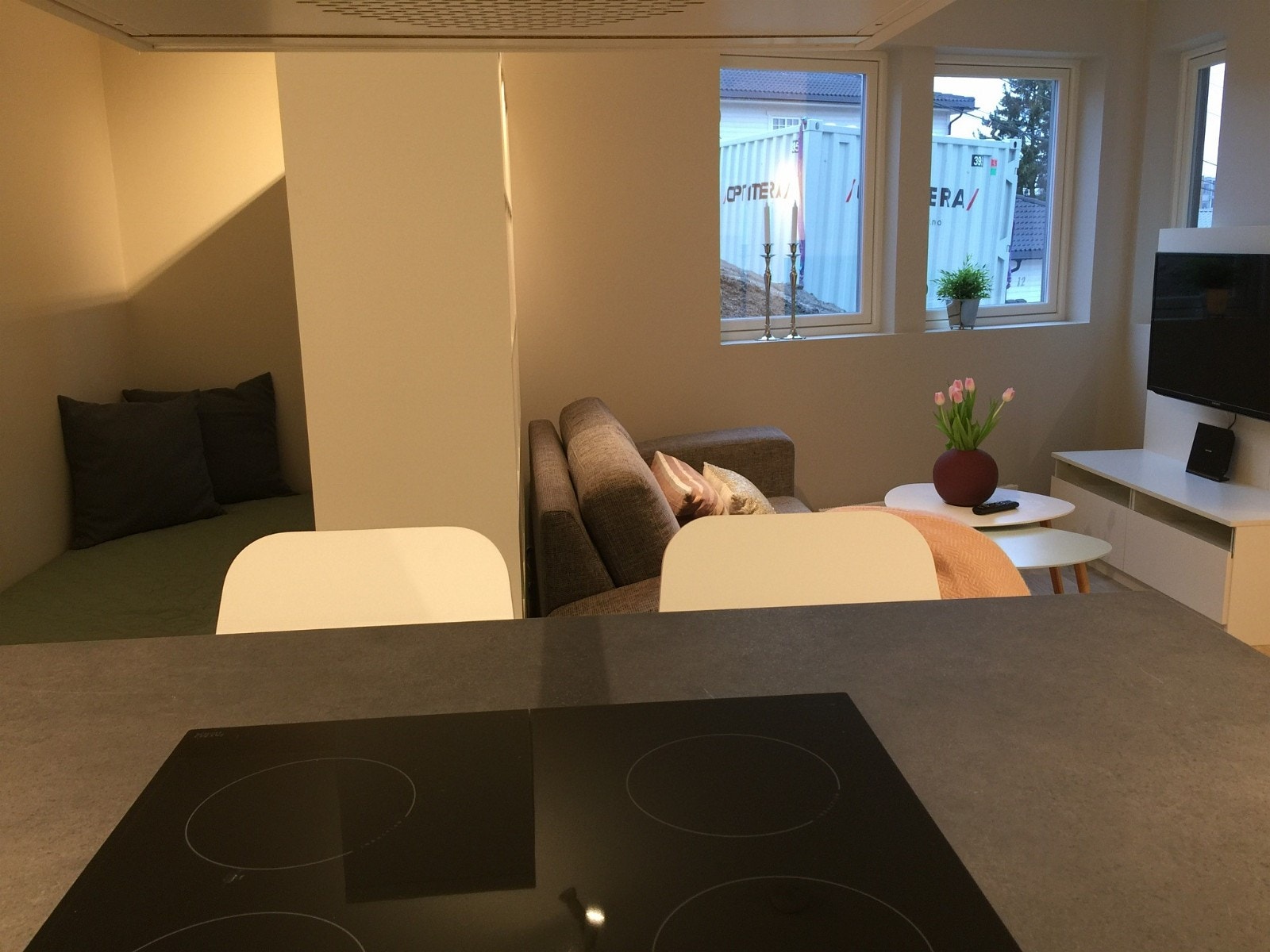 Stuen er delt av med en bokhylle for å lage en sovealkove Galleribilde