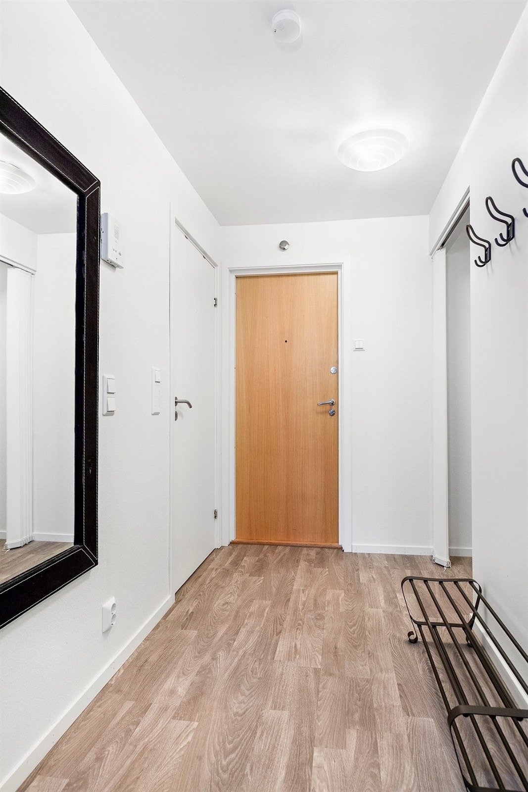 Lys og romslig entré med inngang til "walk-in" garderobe med hylleløsning og god plass til å henge fra seg yttertøy Galleribilde