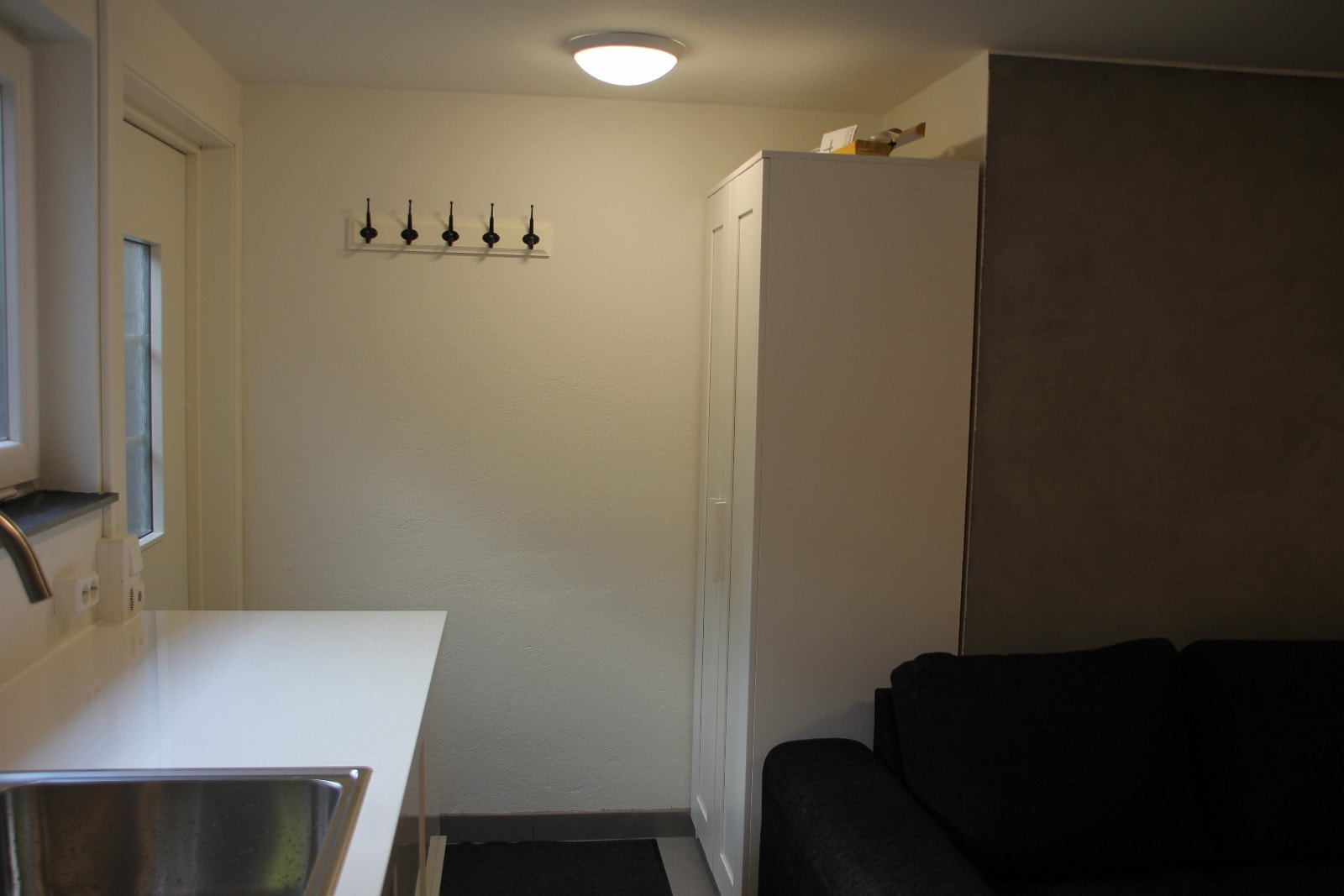 Klesskap og jakke henger ved inngang Galleribilde