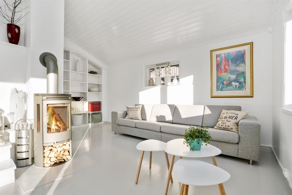 I midten av rommet er det montert en lekker peisovn for ekstra komfort. Fra stuen er det utgang til terrasse og hage. Galleribilde