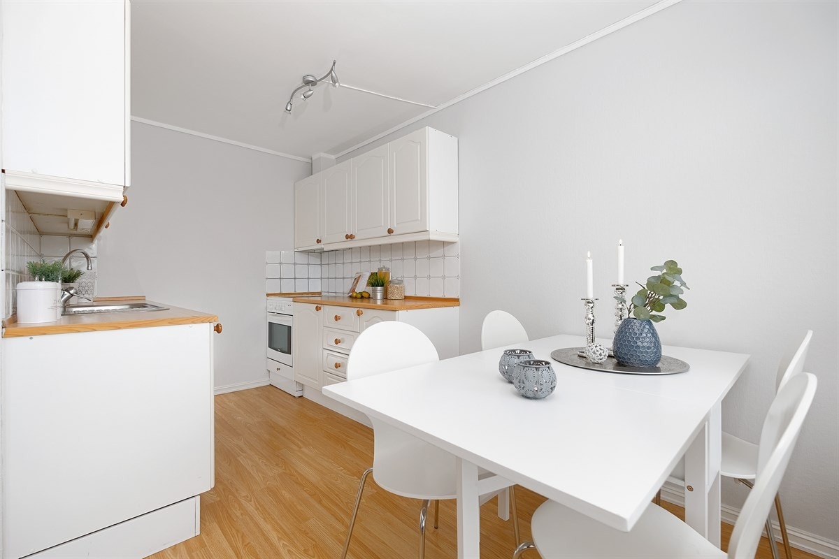 Kjøkkenet har en pen klassisk innrending i hvitt med profilerte fronter. Galleribilde