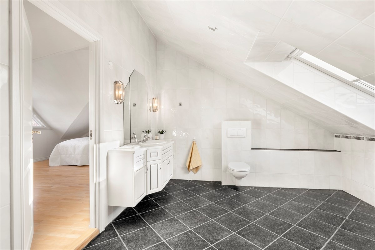 Tilhørende hovedsoverom er et stort bad med varmekabler i gulv og velux takvindu Galleribilde