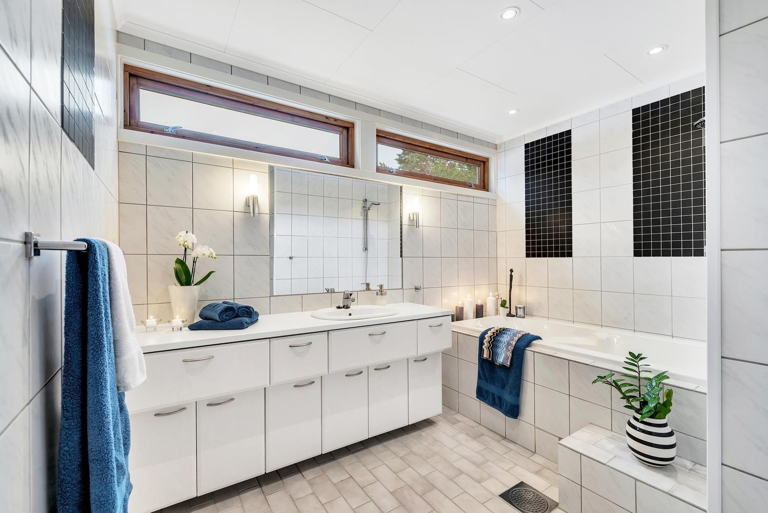 Badet i hovedetasjen har flis på gulv, vannbåren gulvvarme, stort servantskap og boblekar. Galleribilde