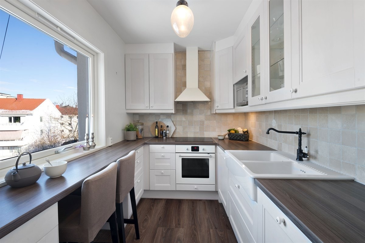 Pent kjøkken fra 2013 med spiseplass og integrerte hvitevarer Galleribilde