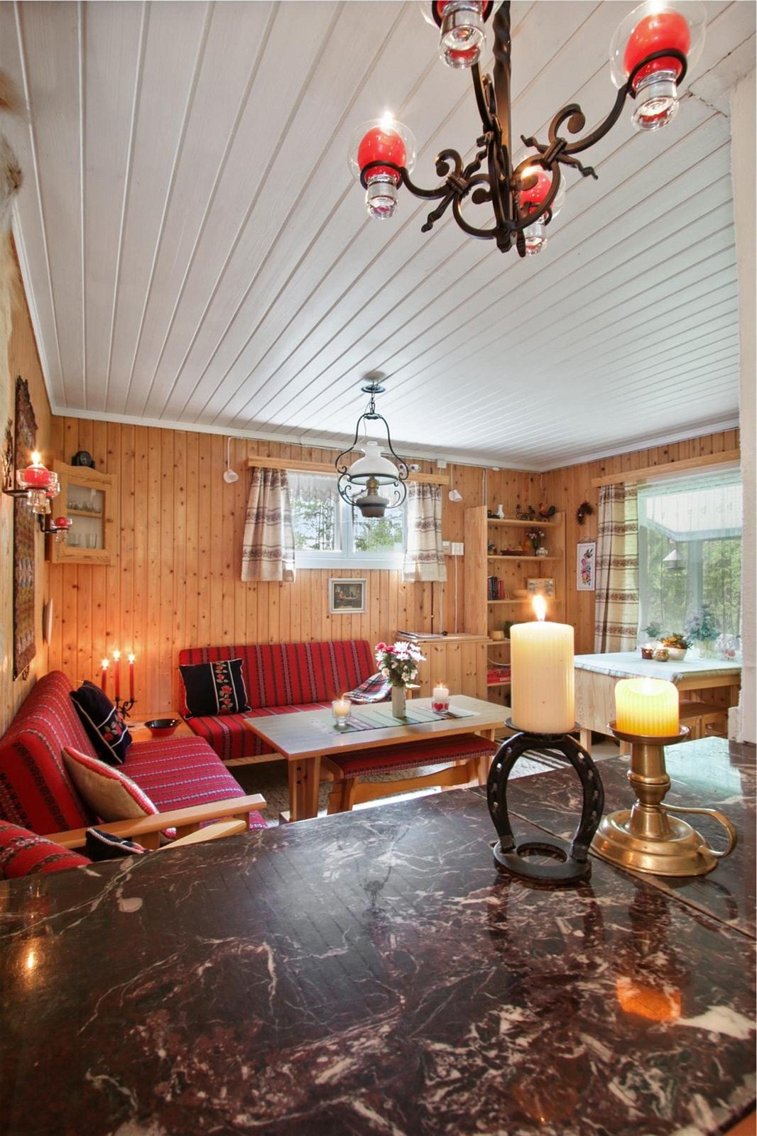 Store vindusflater slipper mye lys inn i den koselige stuen. Galleribilde