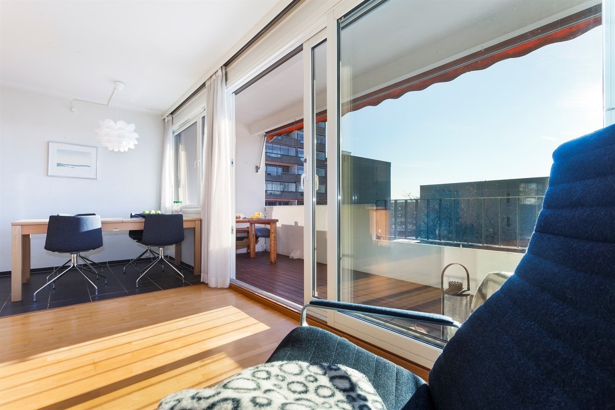 Stor og romslig stue, med kjøkken i delvis åpen løsning og utgang til balkongen Galleribilde