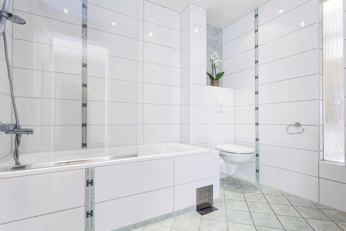 Stort bad, pusset opp i 2010 med badekar med dusj, veggmontert WC og diverse annet baderomsutstyr Galleribilde