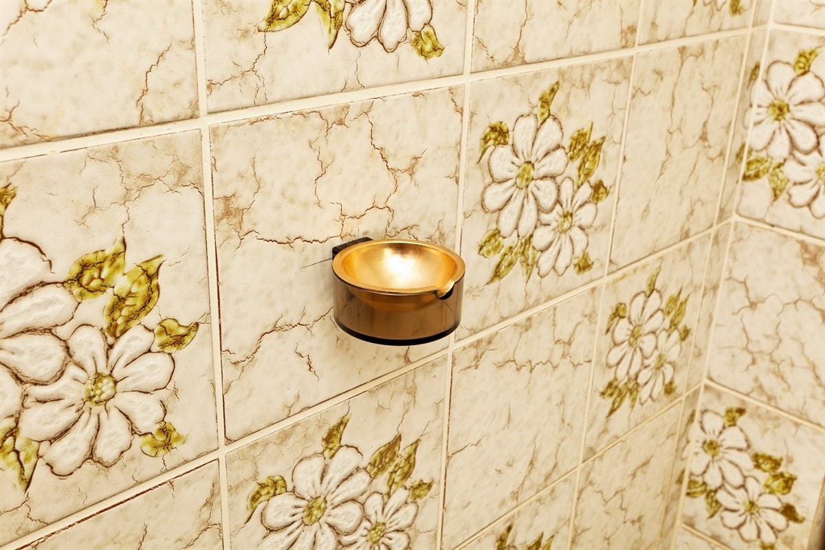 Orginal detalj med matchende gullfarget askebeger på toalettet Galleribilde