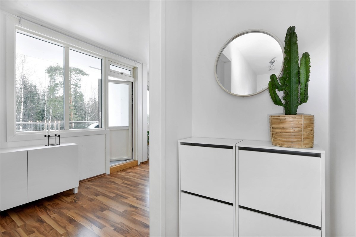 Entreen gir et pent førsteinntrykk av leiligheten, med laminat på gulv og lysmalte vegger, noe som er gjennomgående for øvrige rom i boligen. Galleribilde