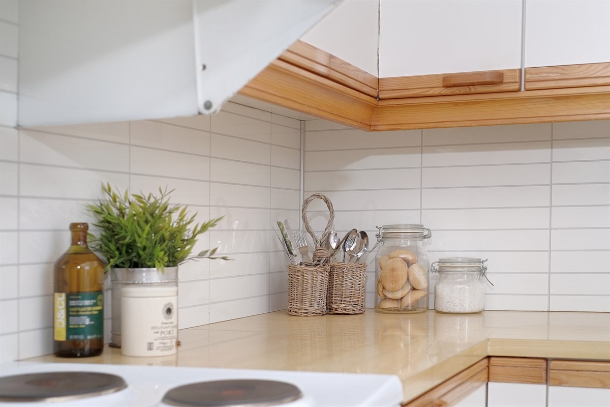 Mellom benk og overskap er det satt på kjøkkenplater som er enkle å rengjøre. Galleribilde