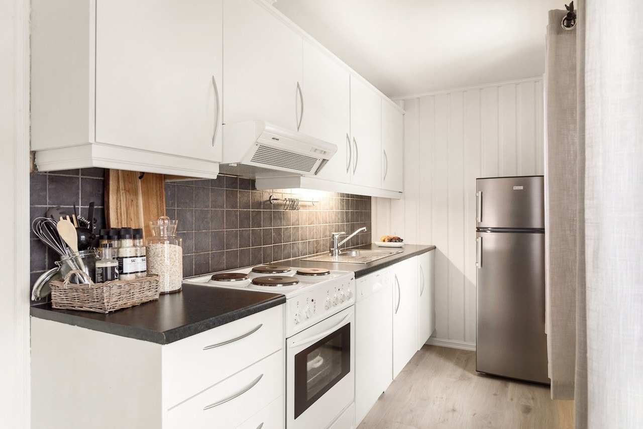 Kjøkkenet er et langstrakt kjøkken med delvis åpen stue- og kjøkkenløsning, her har du godt med oppbevaringsplass og gode arbeidsflater Galleribilde