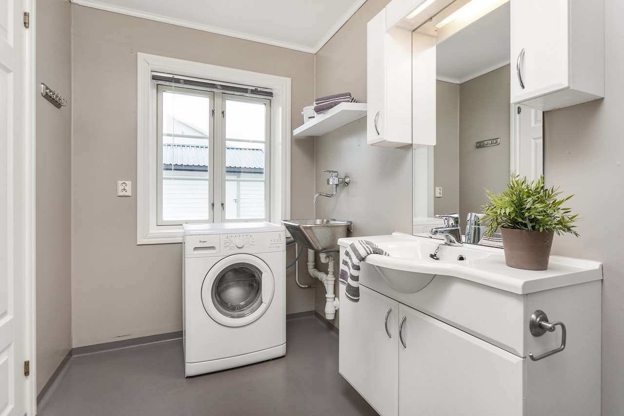 Baderommet er pent og tidløst med flotte fargekombinasjoner. Her har du opplegg for vaskemaskin, i tillegg til utslagsvask! Galleribilde