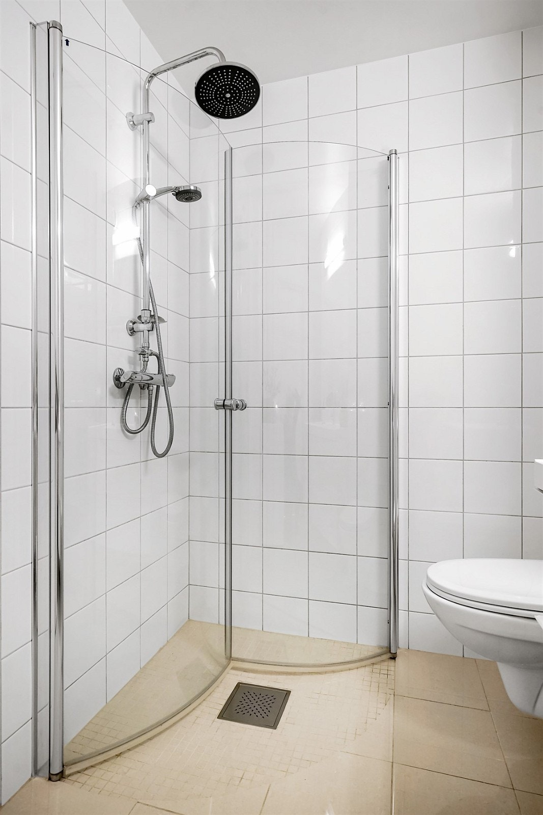 Dusjhjørne med buede svingdører, hjelpesluk, overdusj og termostatstyrt blandebatteri. Galleribilde