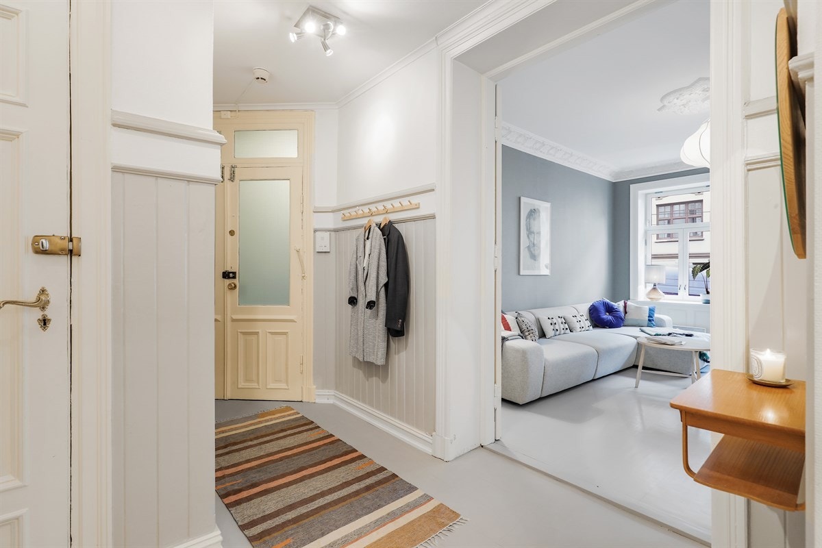 Innbydende entré med plas for å henge av seg ytterklær og sko. Stort garderobeskap plasser i gangen. Galleribilde