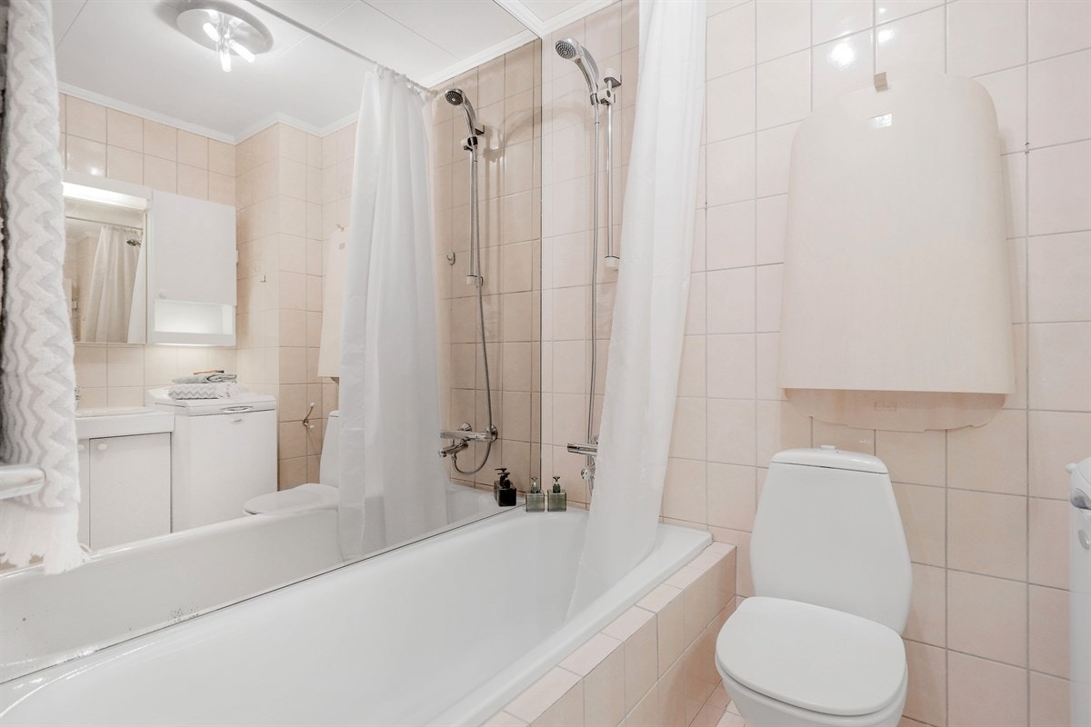 Badet har badekar, wc, servant og opplegg for vaskemaskin. Stellebord montert over wc. Galleribilde