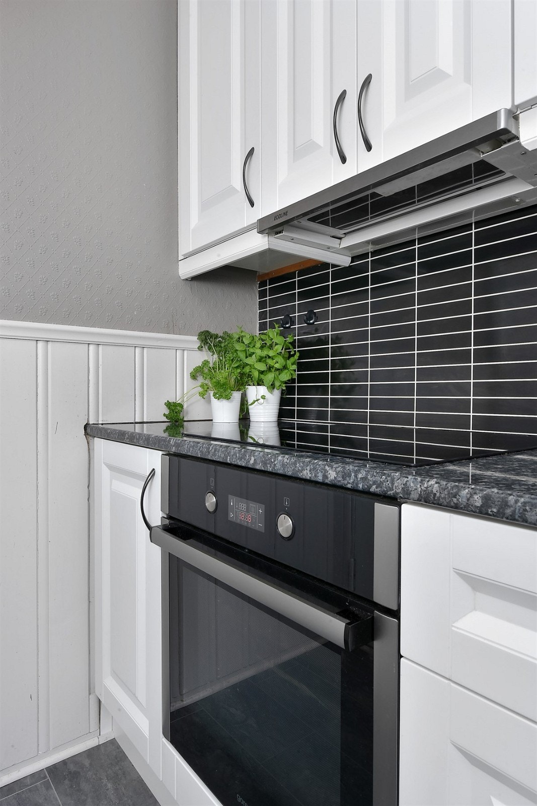 Kjøkkenet utstyrt med integrert stekeovn, induksjonstopp, oppvaskmaskin og ventilator. Galleribilde