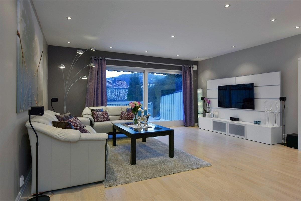 Stuen har downlights i himling, malte flater på vegg og parkett på gulv med varmekabler. Galleribilde