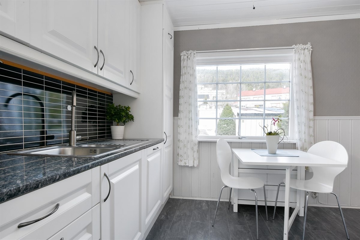 Videre er det laminert benkeplate med dobbel vaskekum, flisplater over benk og benkebelysning. Innredningen er fra Monter og av nyere dato. Galleribilde