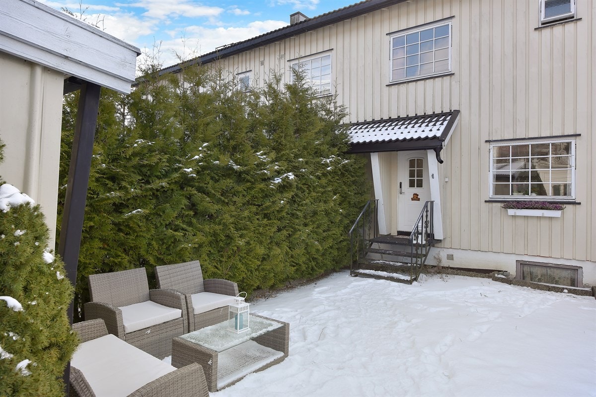 På forsiden av huset kommer man inn i en grusbelagt gårdsplass med god plass til hagemøblement. Galleribilde