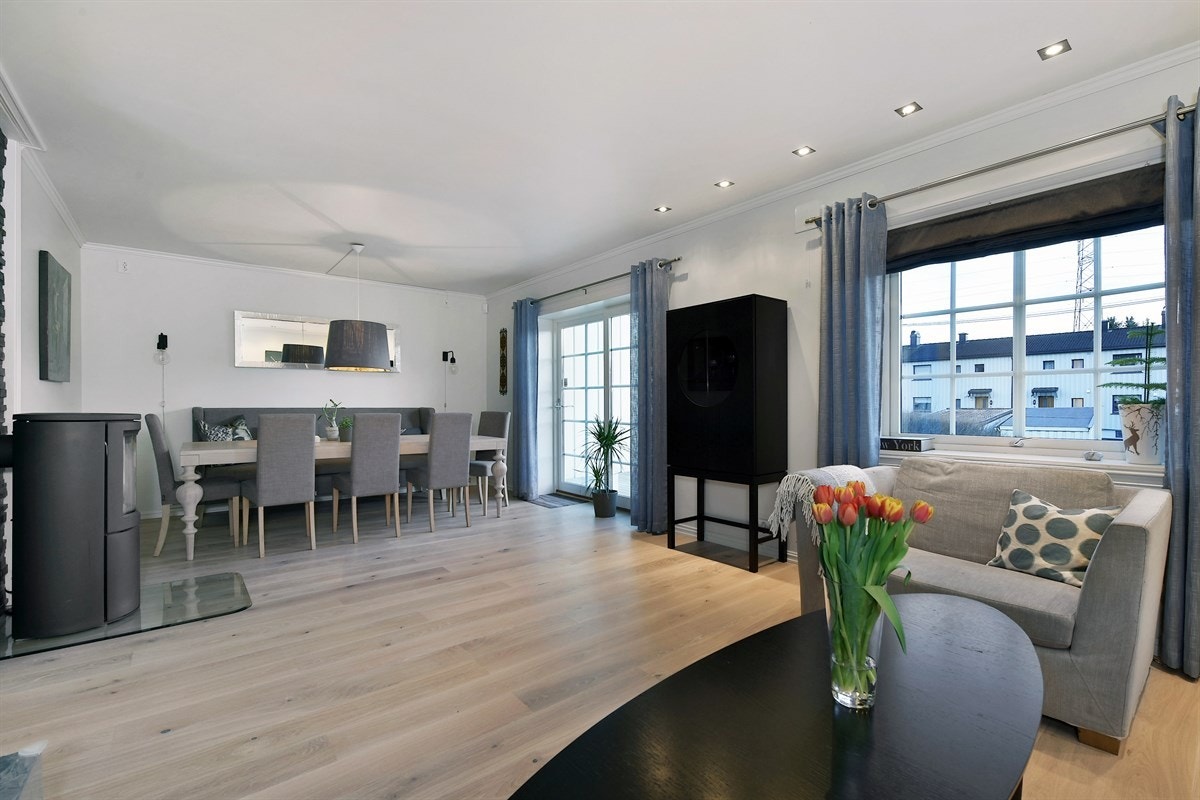 Stuen oppleves som romslig og innbydende med eikeparkett på gulv, downlights belysning, lyse vegger og en flott, mørk fondvegg som gir en spennende kontrast. Galleribilde