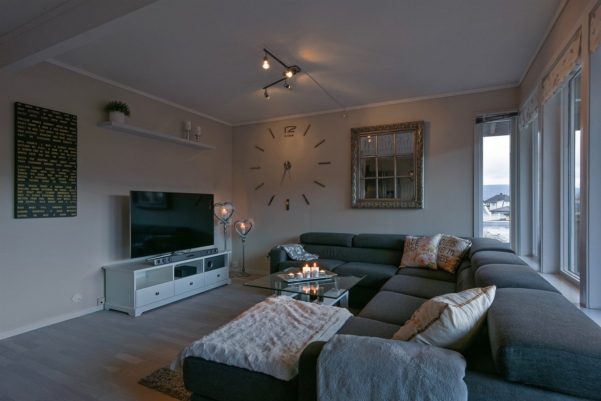 Stuen har store vindusflater som gir rommet rikelig med naturlig lys, samt parkett på gulv og lysmalte vegger. Galleribilde