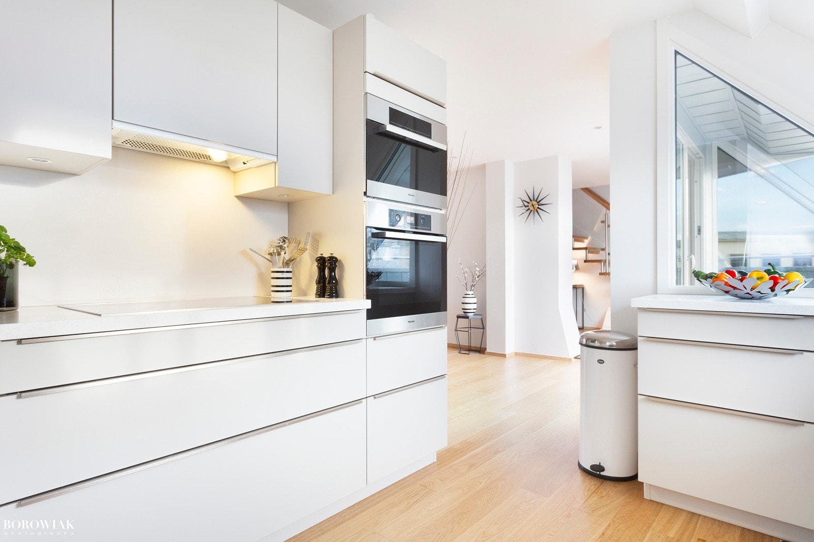 Velutstyrt og moderne kjøkkeninnredning fra 2013 med lys grå fronter og håndtak i stål Galleribilde