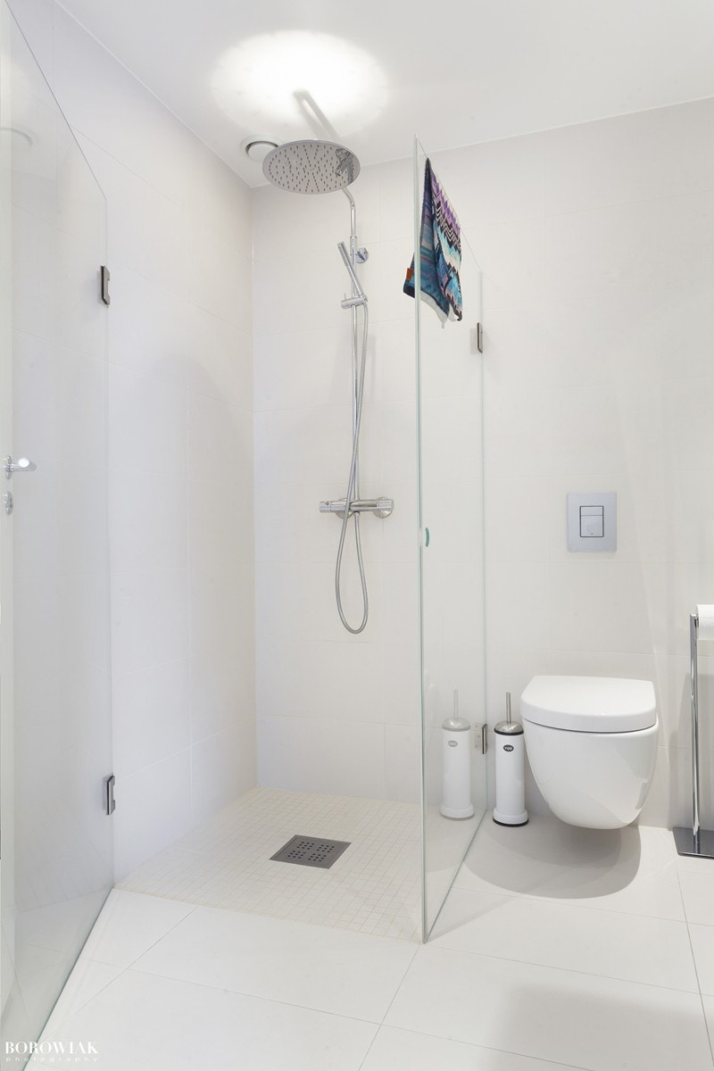 Dusjhjørne med foldbare glassdører gir badet et rent og moderne inntrykk Galleribilde