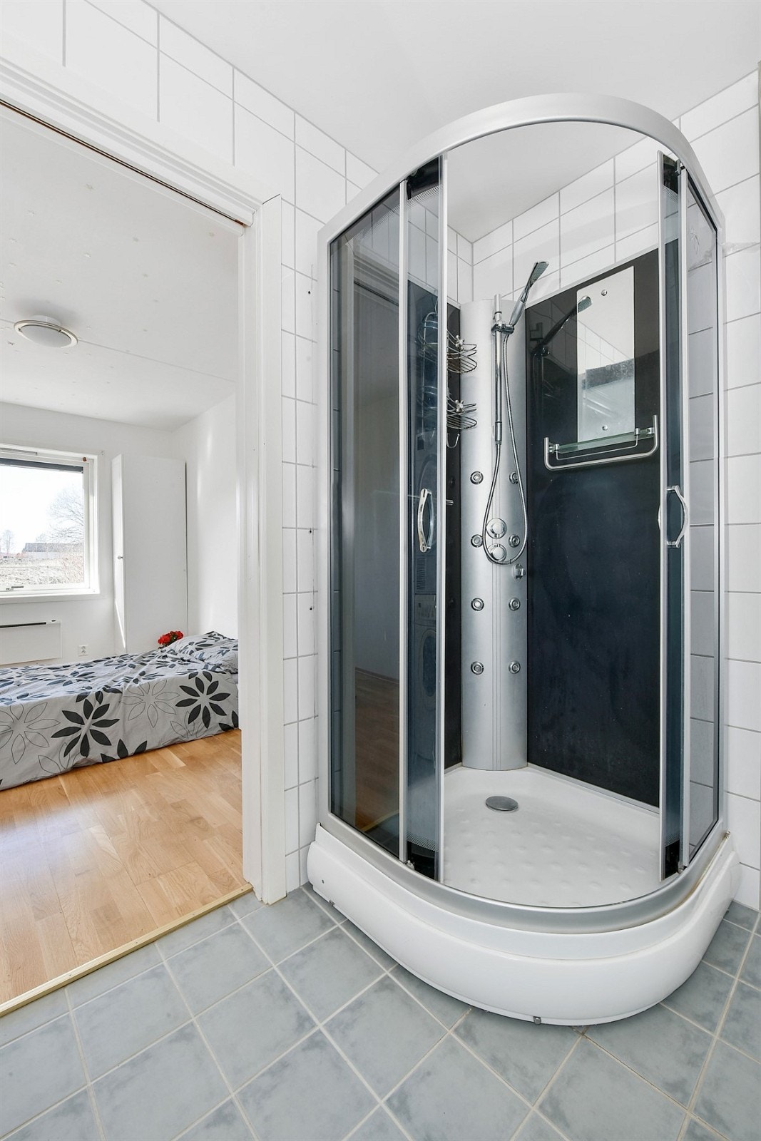Boligen har et pent bad som er utstyrt med grå fliser på gulv og lyse fliser på vegg. Galleribilde