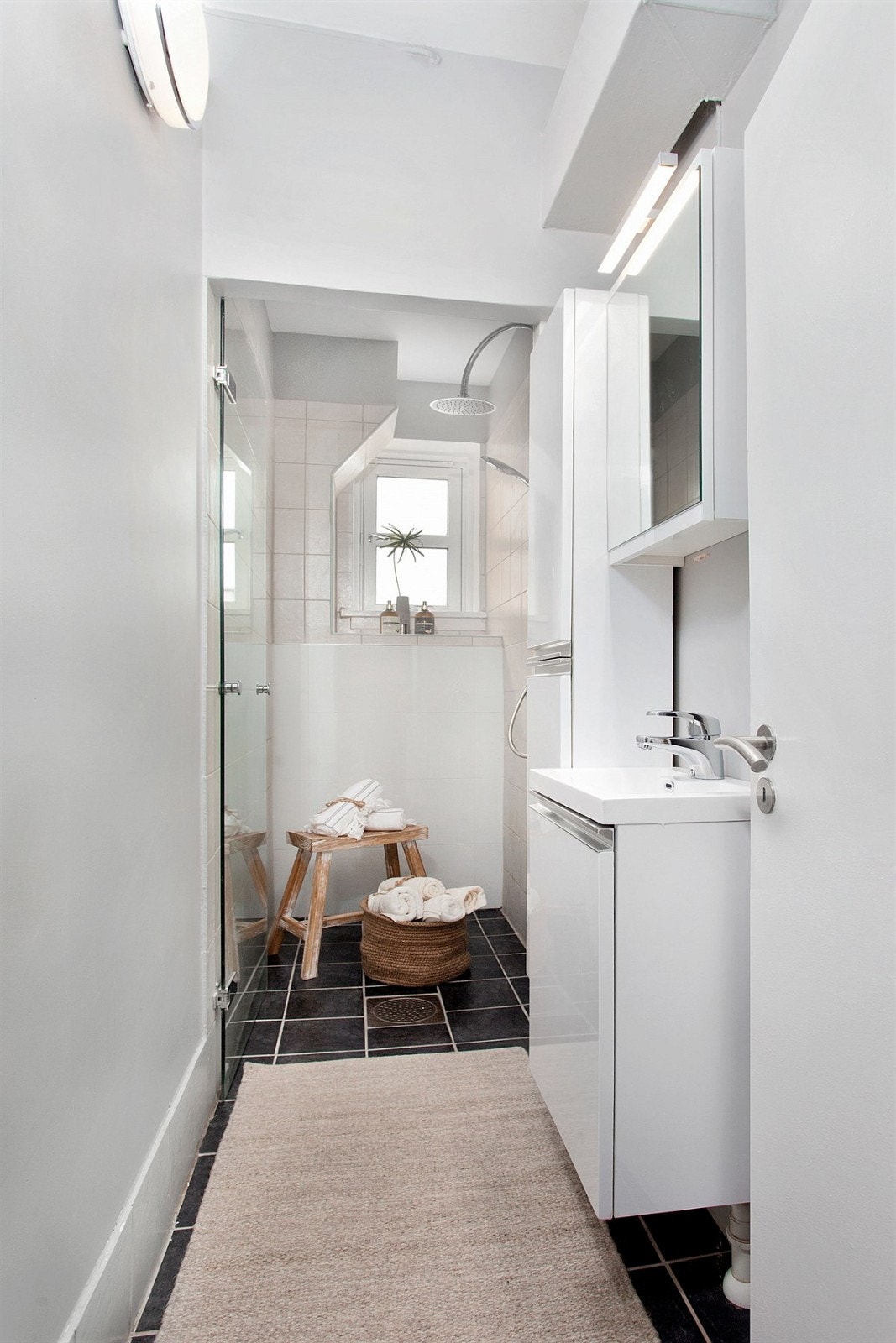 Pent flislagt bad med praktisk dusjløsning med glassdør og ny servant med underskap. Galleribilde