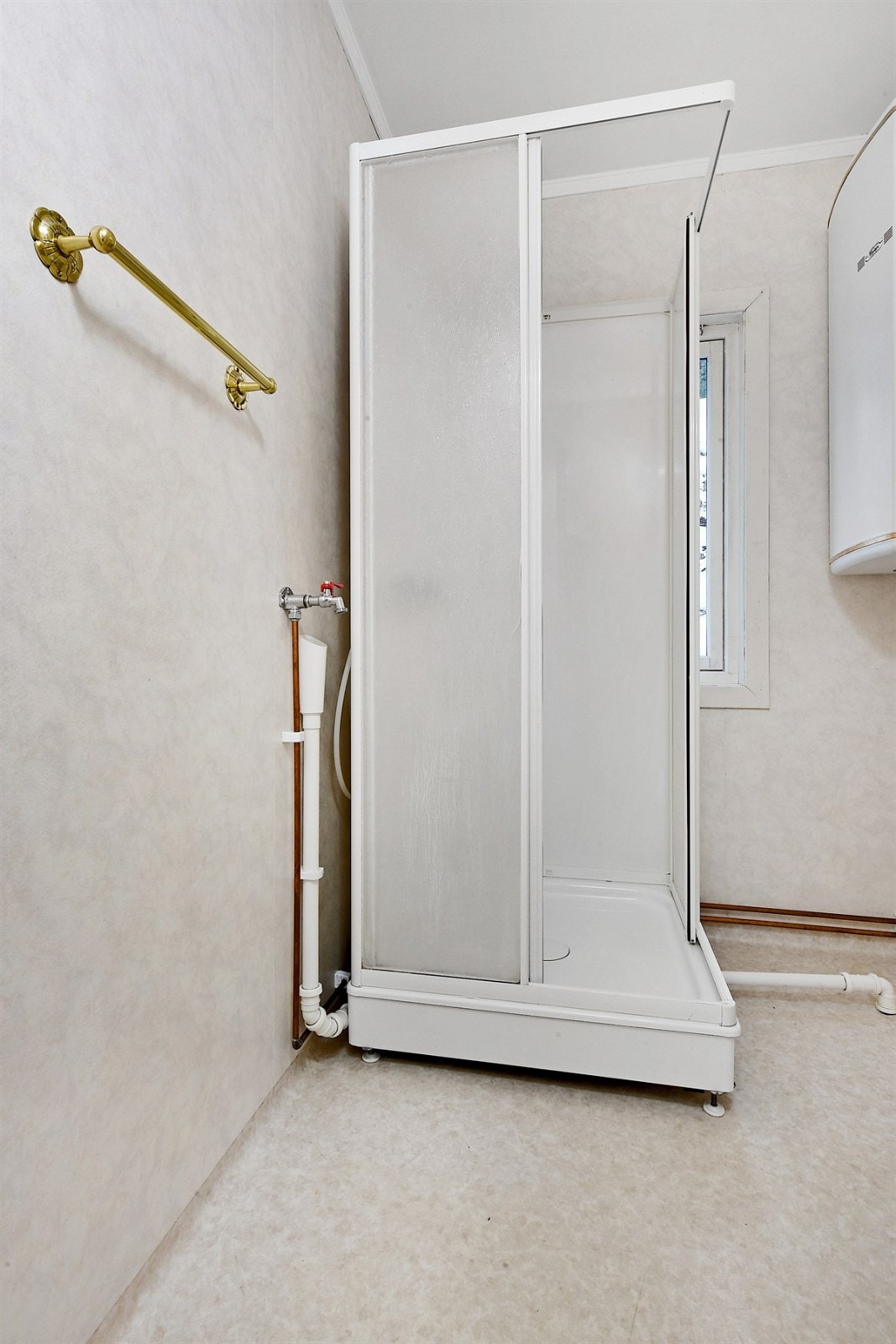 Innredningen består av veggmontert servant, speil med overlys, veggskap, frittstående toalett og et dusjkabinett. Galleribilde