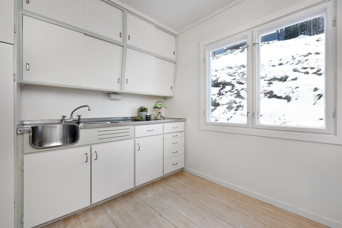 Leiligheten har et sjarmerende kjøkken med eldre, plassbygd innredning. Galleribilde