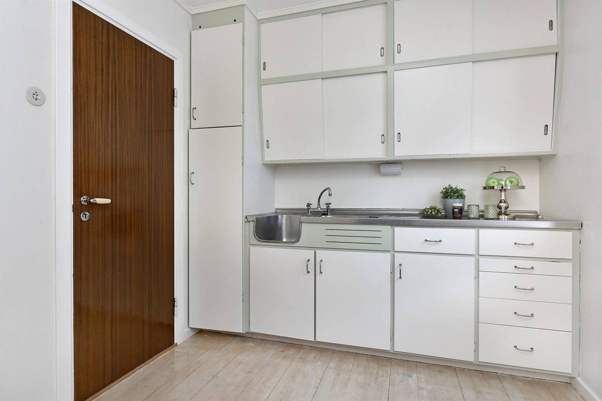 Kjøkkenet har høyskap, skrå overskap, bra med benkeskap og flere skuffer - alle med hvite, glatte fronter. Galleribilde