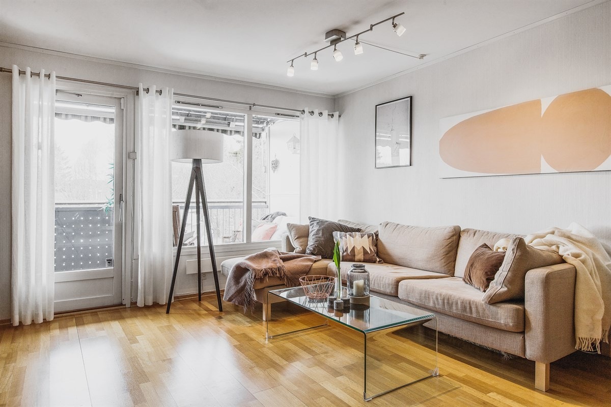 Innendørs i stuen er atmosfæren privat, og høyreiste vindusflater ivaretar utsynet mot skogen. Galleribilde