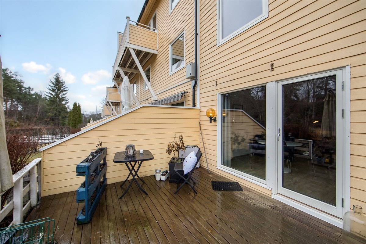 Utgang fra stue til terrasse på 25 m² med levegger fra 2015 og støttemur rundt opparbeidet hage Galleribilde